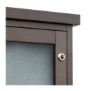 Detail of glazed Man-made Timber, recycled plastic noticeboard showing door and lock detail
